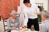 foto of restaurant  - Senior couple being served food in a restaurant - JPG 