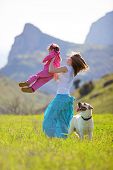 picture of family  - Happy family walking with dog in green field - JPG 