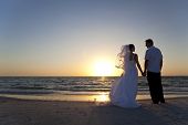 stock photo of beach  - Wedding of a married couple bride and groom together at sunset on a beautiful tropical beach - JPG 