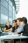 foto of business people  - Group of young business people sitting in a row at table on office terrace outdoor - JPG 