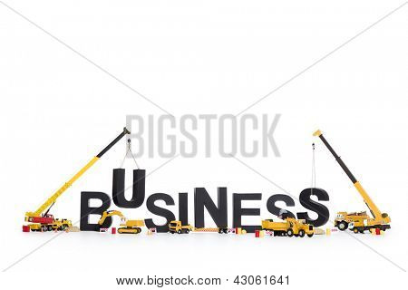 Picture or Photo of Business start up concept: Black alphabetic letters forming the word business being set up by group of construction machines, isolated on white background.