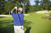 picture of golfer  - A golfer hits on to a green in the afternoon - JPG 