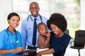 image of medical doctors  - happy afro american mother holding her baby boy after checkup with nurse and doctor - JPG 
