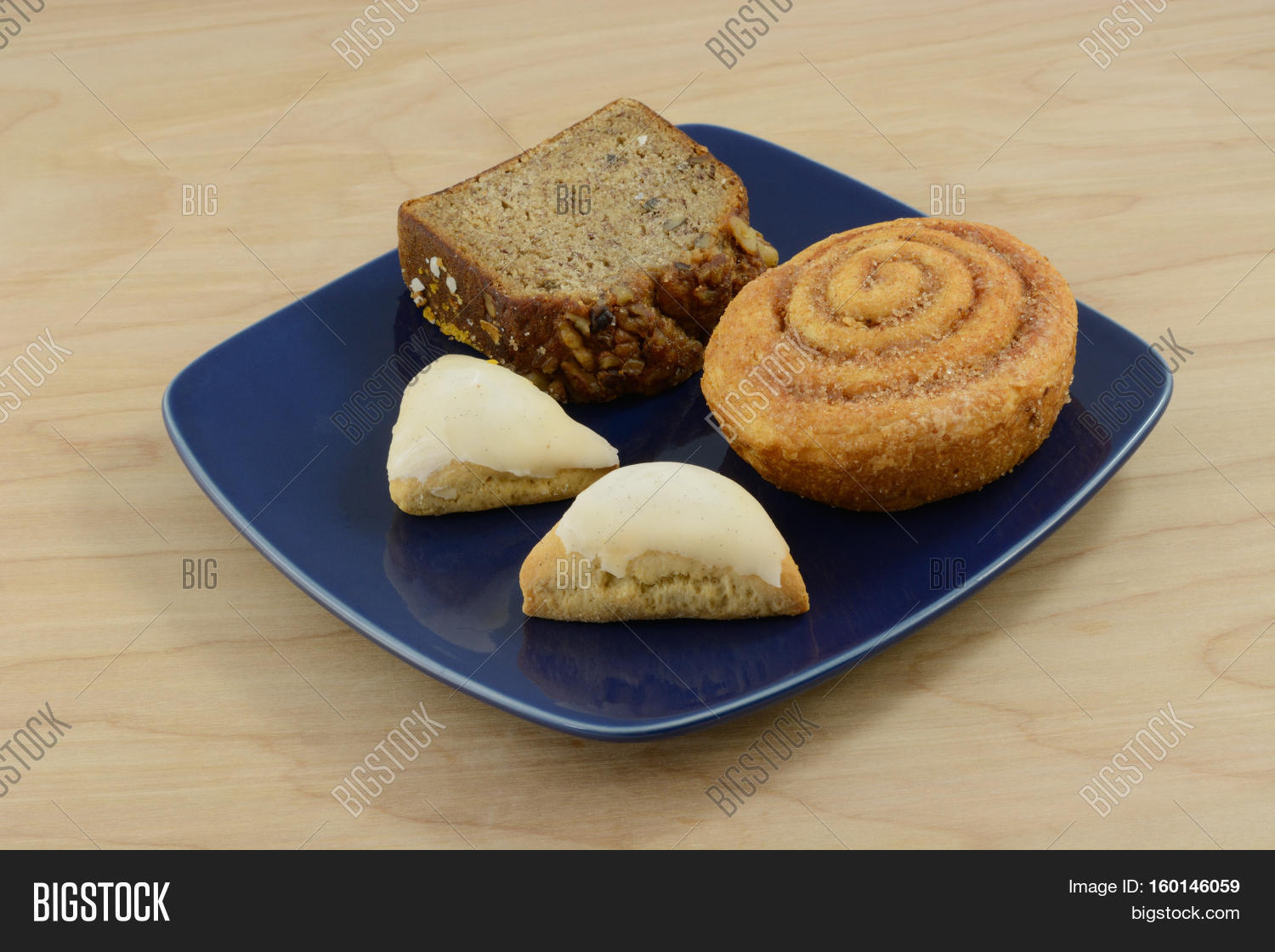 Assorted breakfast breads and rolls on a blue plate Stock Photo & Stock