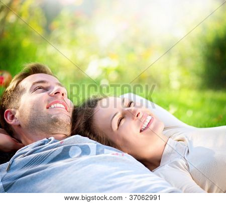Picture or Photo of Happy Smiling Couple Relaxing on Green Grass.Park.Young Couple Lying on Grass Outdoor