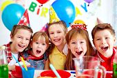 stock photo of group  - Group of adorable kids looking at camera at birthday party - JPG 