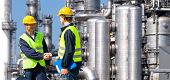 stock photo of handshake  - Two petrochemical contractors closing a deal in front of an oil refinary - JPG 
