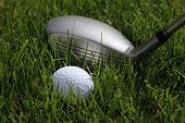 stock photo of golf  - golf hybrid club with a golf ball lying in low rough - JPG 