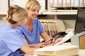 picture of meeting  - Two Nurses Working At Nurses Station - JPG 