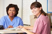 pic of nurse  - Two Nurses In Discussion At Nurses Station - JPG 