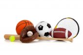 foto of sports  - Assorted sports equipment including a basketball soccer ball tennis ball baseball bat tennis racket football and baseball glove on a white background - JPG 