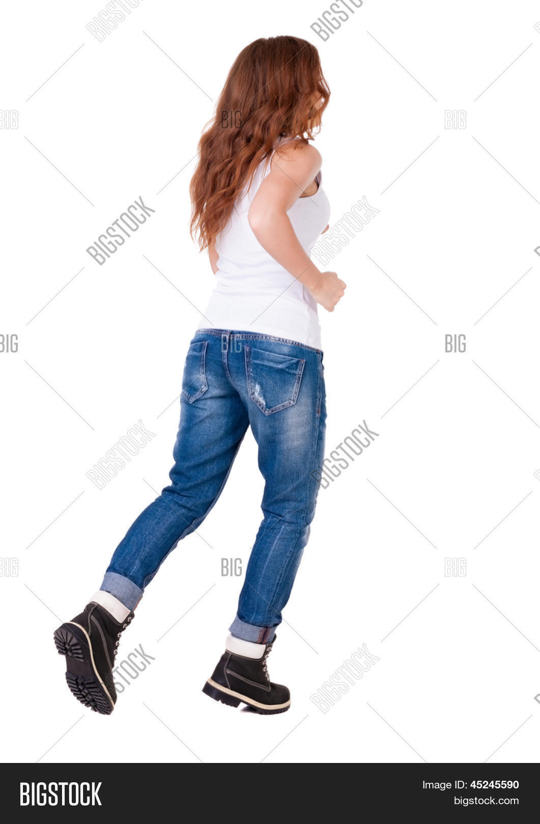 back view running woman in jeans. beautiful redhead girl in motion.Red