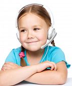 picture of helpline  - Cute young girl is working as an operator at helpline talking with customer using headset - JPG 