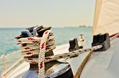 stock photo of wrapped  - Red and white line wrapped around winch of sailboat - JPG 