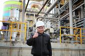 picture of industrial  - industrial engineer with thumbs up standing beside pipeline inside oil refinery - JPG 