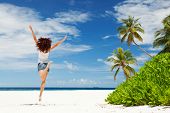 foto of beach  - happy young woman jumping on the tropical beach - JPG 