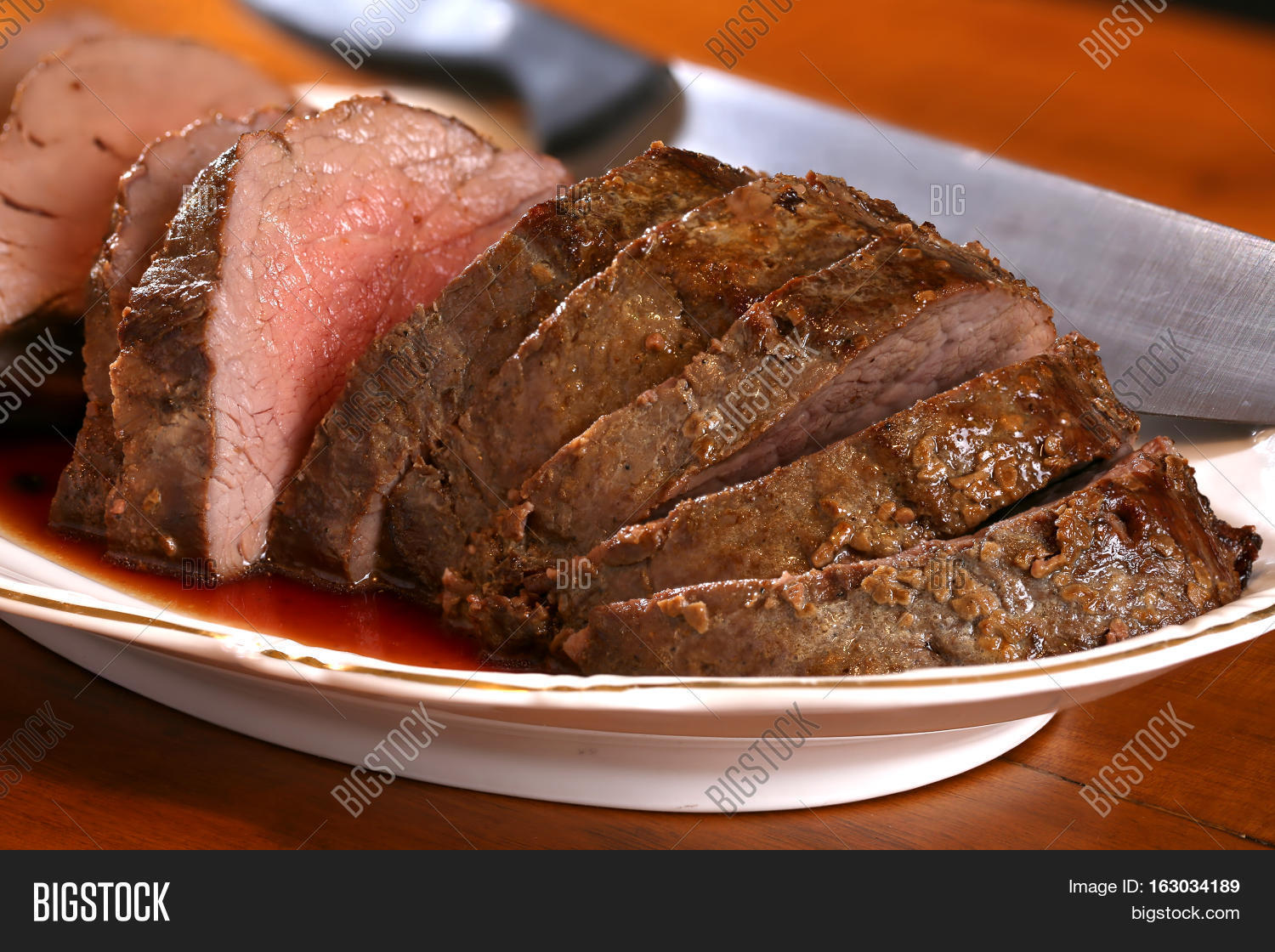 Medium rare beef tenderloin on a platter waiting to be served Stock