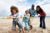 foto of family  - Family playing tug of war on beach - JPG 