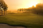 foto of golf  - golf course at dawn backlit by rising sun - JPG 