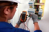 picture of construction worker  - Female electrician checking a fusebox - JPG 