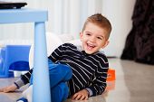 picture of kindergarten  - five years old child laughing in the living room or kindergarten portrait of a happy kid playing - JPG 