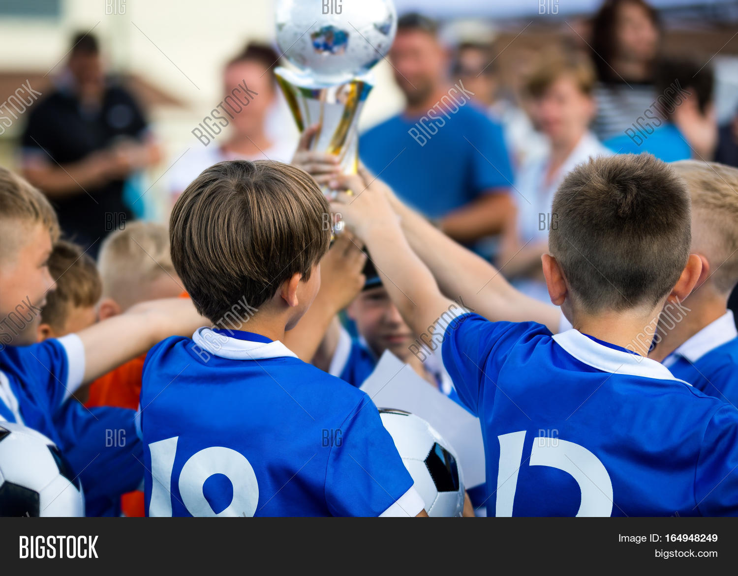 Young Soccer Players Holding Trophy. Children Soccer Football Champions
