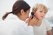 image of medical doctors  - Doctor auscultating the ear of a child in examination room - JPG 