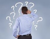 image of standing  - Confused businessman standing in front of a wall of question marks - JPG 