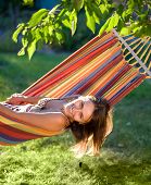 stock photo of teeter  - Happy Young Woman relaxing in hammock - JPG 