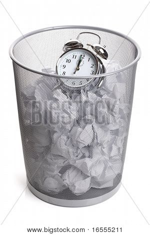 Picture or Photo of Alarm clock in a wastepaper bin concept for a time waste of time
