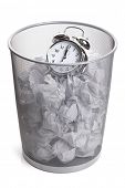 stock photo of time  - Alarm clock in a wastepaper bin concept for a time waste of time - JPG 