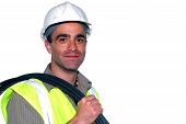 foto of construction worker  - friendly construction worker with a cable on his shoulder looking into the camera - JPG 