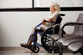 pic of wait  - Pensive elderly woman on wheelchair waiting in hospital lobby - JPG 
