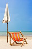 image of beach  - An empty wooden beach chair at the beach - JPG 