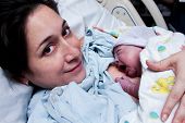 picture of infants  - Beautiful new mother happy holding her infant baby after giving birth in hospital - JPG 