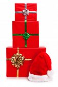 picture of wrapped  - Santa Claus hat and three red gift wrapped Christmas presents with ribbons and bows - JPG 