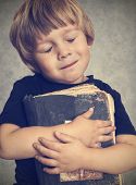 stock photo of boy  - Little boy hugging an old book - JPG 
