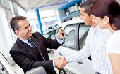 stock photo of handshake  - Couple buying a car and salesman handling keys - JPG 