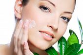 stock photo of beauty  - Woman applying moisturizer cream on face - JPG 