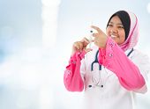 foto of medical doctors  - Muslim female medical doctor filling the syringe getting ready for a medical procedure - JPG 