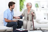 picture of pressure  - Young man taking the blood pressure of an older lady - JPG 