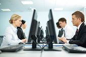 stock photo of computer  - Two rows of businesspeople working on computers - JPG 