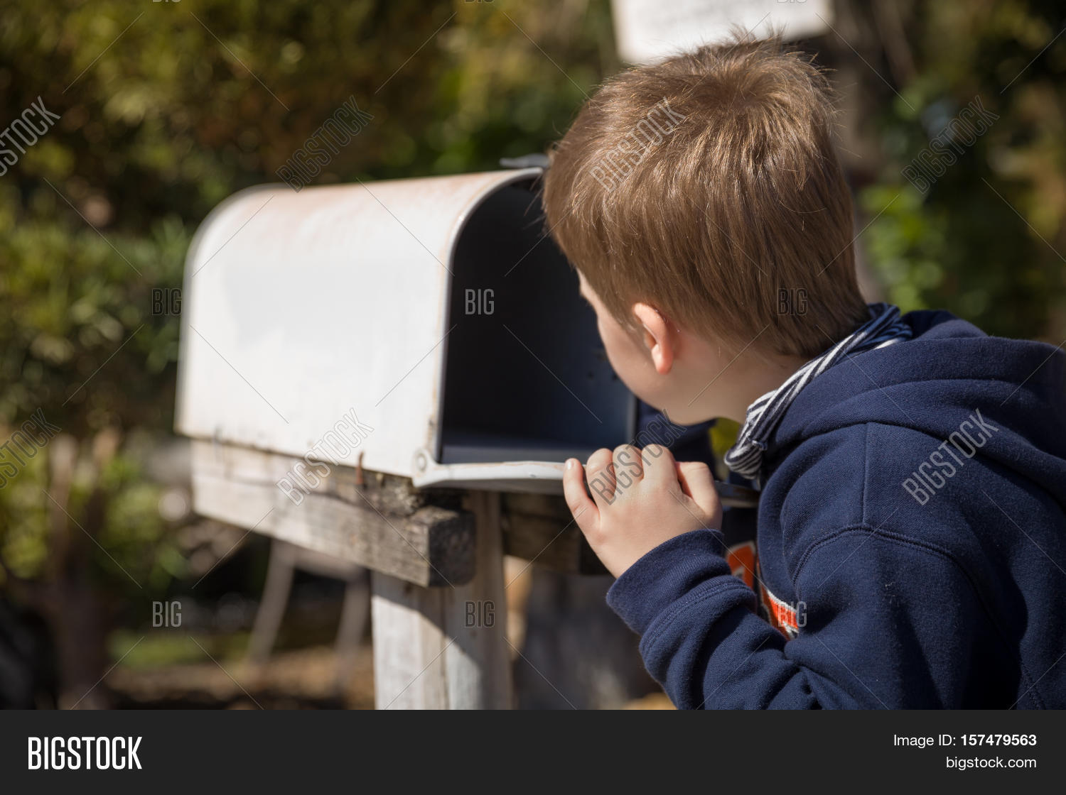 School boy opening a post box and checking mail. Kid waiting for a