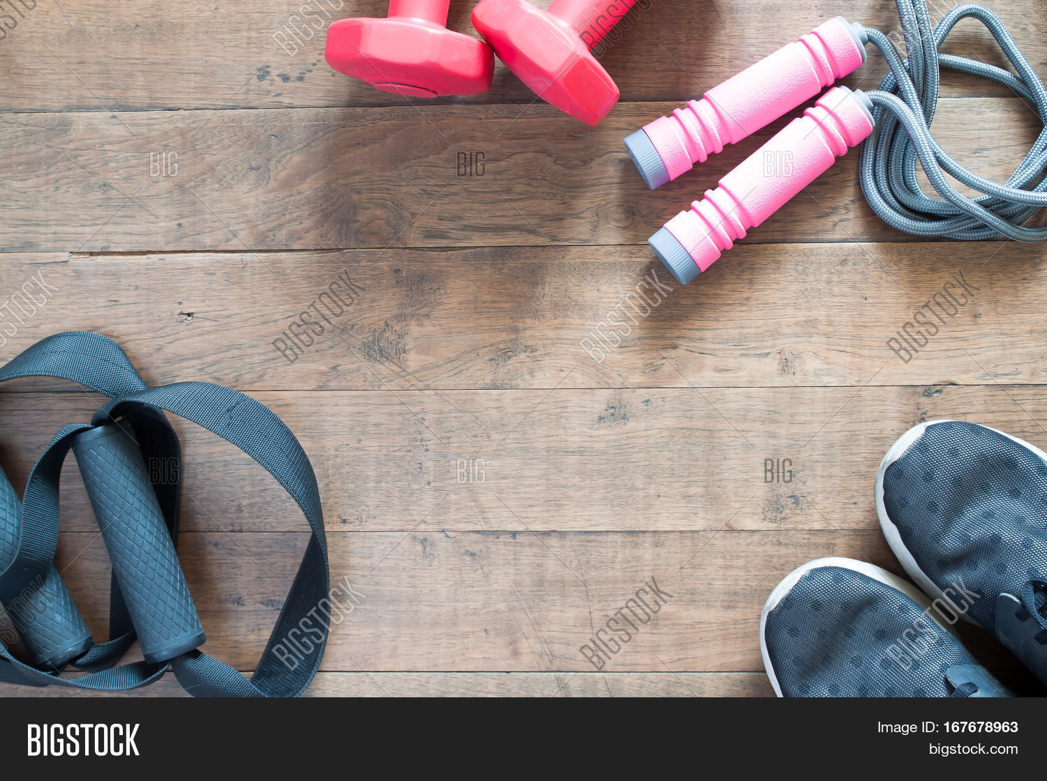Flat lay of cellphone red dumbbells and sport equipment on wood