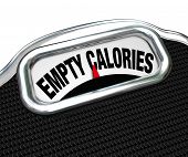 picture of food  - The words Empty Calories on the display of a scale to illustrate the importance of eating nutritional foods for good health instead of junk or fast food such as snacks - JPG 