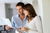 picture of newspaper  - Couple at home reading news on newspaper and internet - JPG 