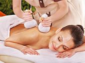 foto of pressure  - Woman getting herbal ball massage treatments  in spa - JPG 