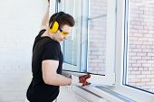 picture of windows  - Man worker mounting window on balcony - JPG 