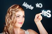 picture of teeter  - Fun marriage proposal concept as a beautiful young woman with a lovely smile and amused look teeters between Maybe No and Yes virtual buttons before selecting the Yes - JPG 