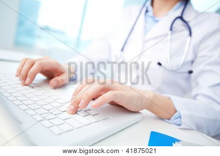 Picture or Photo of Close-up of a medical worker typing on laptop